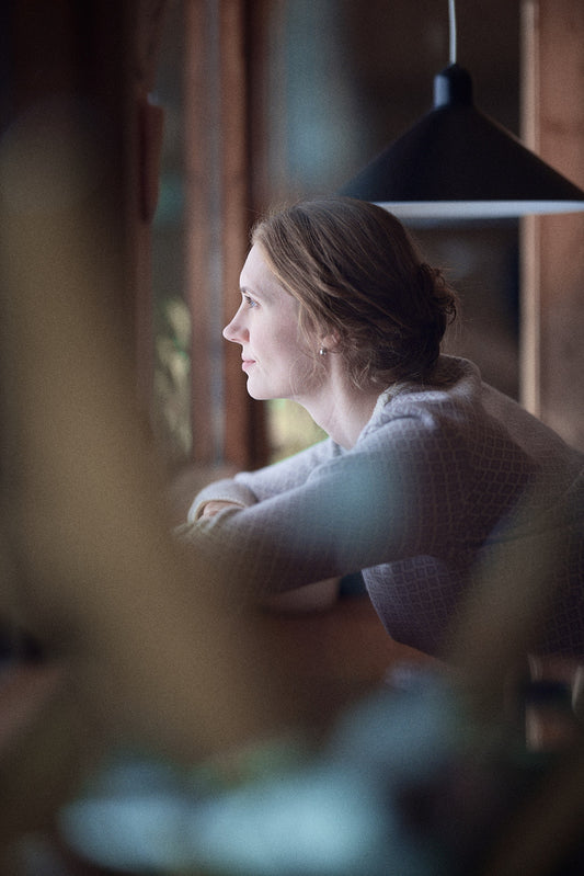 Illustrasjonsfoto: kvinne som ser tankefullt ut av vinduet.