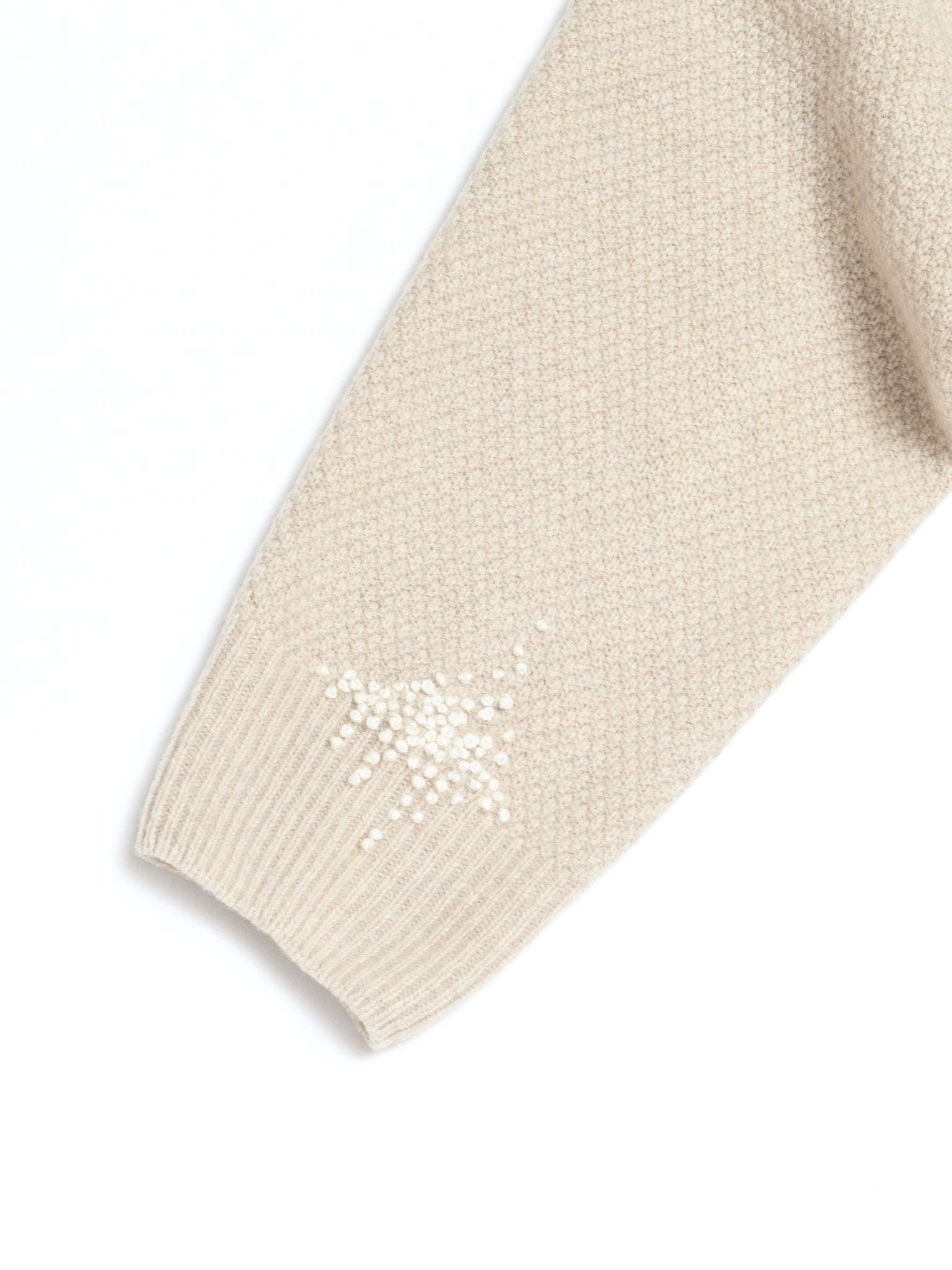 Reparert strikkegenser med broderi.