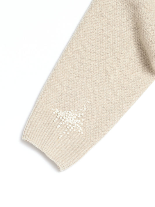 Reparert strikkegenser med broderi.